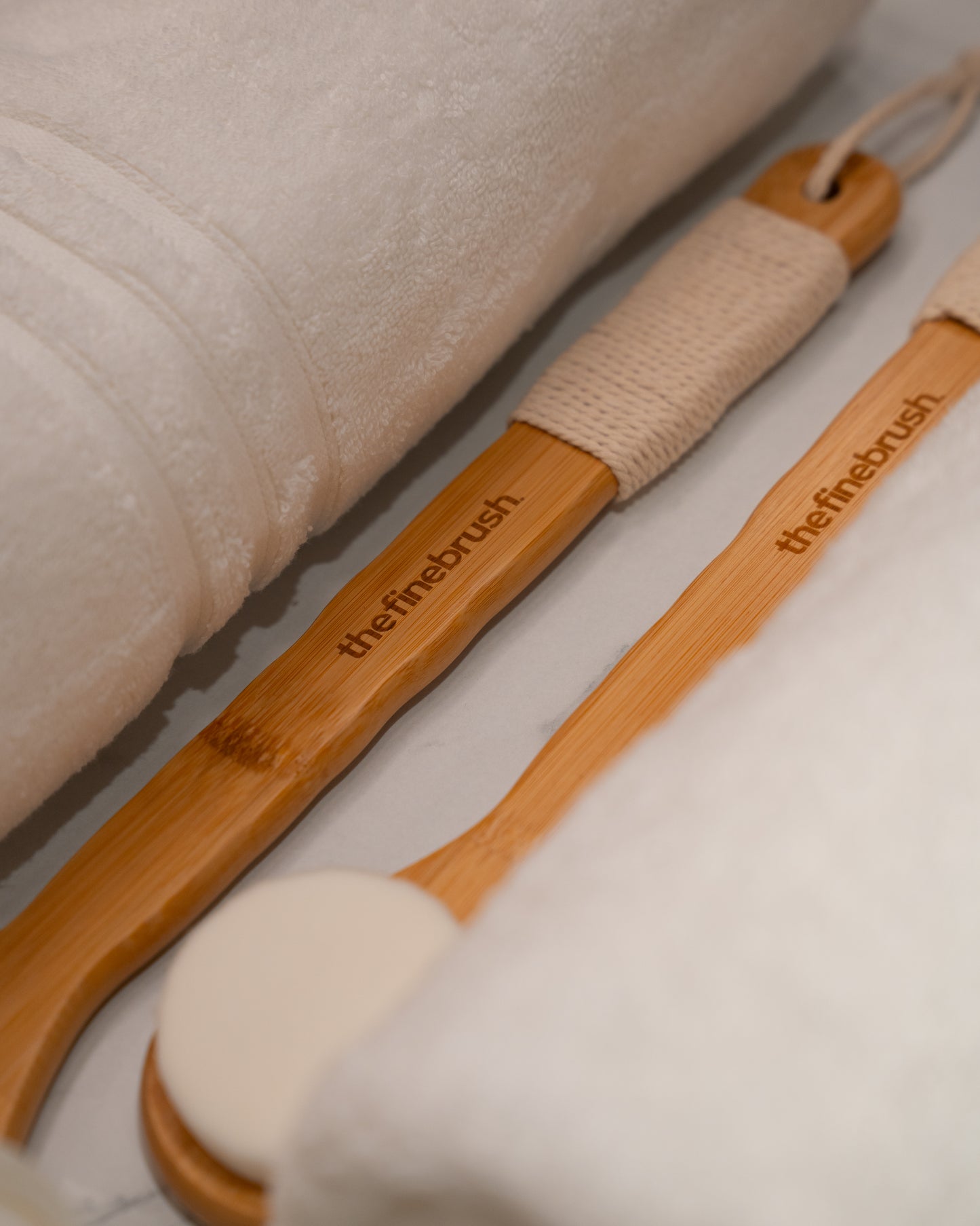 Bamboo shower brush resting on linen — ultra-soft bristles for gentle daily exfoliation and skin barrier care