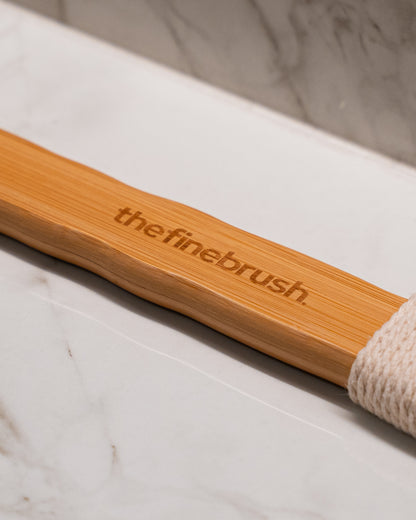 The Fine Brush bamboo handle on stone — natural sustainable materials gentle enough for sensitive and KP-prone skin