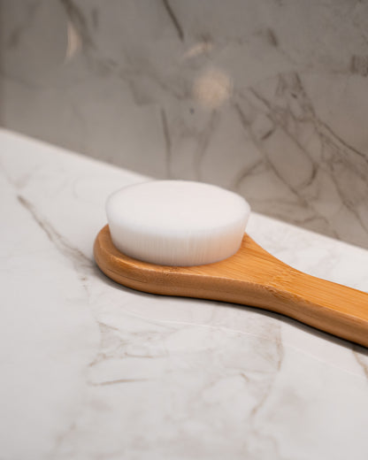 Bamboo body brush angled shot — gentle exfoliating shower brush designed to protect the skin barrier